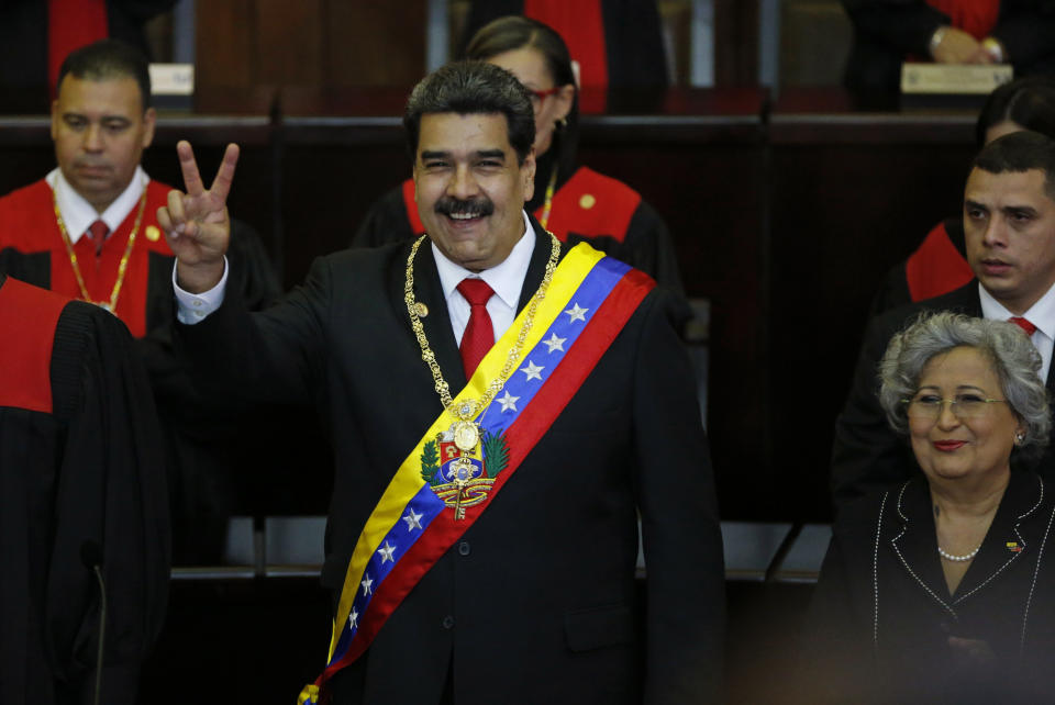 FILE - In this Jan. 10, 2019 file photo, Venezuela's President Nicolas Maduro flashes a vee for victory during his swearing-in ceremony at the Supreme Court in Caracas, Venezuela. Maduro was sworn in for a second term as president, but most Latin American countries, the United States and Canada denounced his government as illegitimate, arguing his re-election was a farce. (AP Photo/Ariana Cubillos, File)