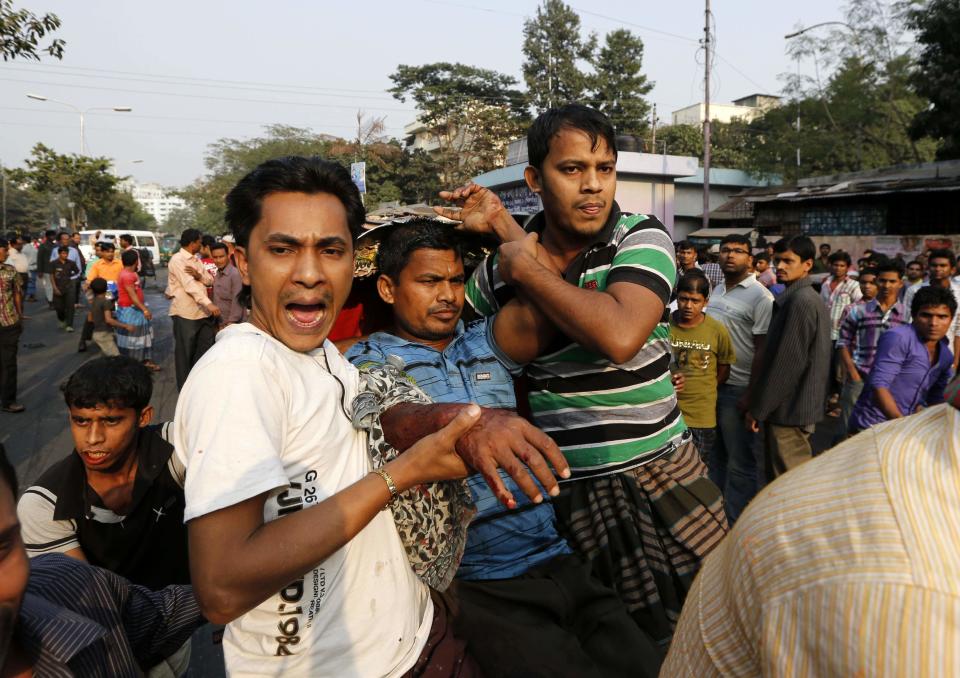 People rescue a man injured by the rubber bullets fired by police during clashes between Bangladesh's Jamaat-e-Islami party activists and police, in Dhaka