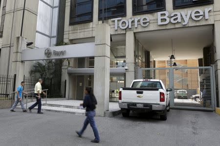 People walk in front of the Bayer headquarters building in Caracas March 1, 2016. Picture taken March 1, 2016. REUTERS/Marco Bello