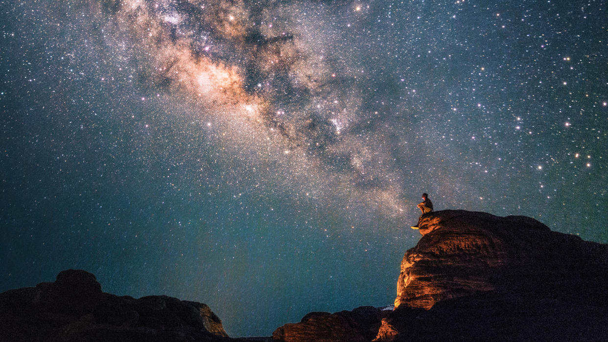  Silhouette of a man looking at the Milky Way Stars shining above the Grand Canyon of Thailand (Sam Phan Bok). 