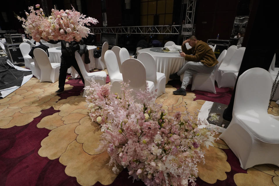 Workers from a wedding planner company set up decorations a day before an unmasked wedding banquet in Beijing on Friday, Dec. 11, 2020. The wedding planner reported 50% decrease in business over the previous year but is optimistic for the future as couples who pushed back their weddings are helping revitalize the industry as the pandemic fades and restrictions are lifted in China. (AP Photo/Ng Han Guan)