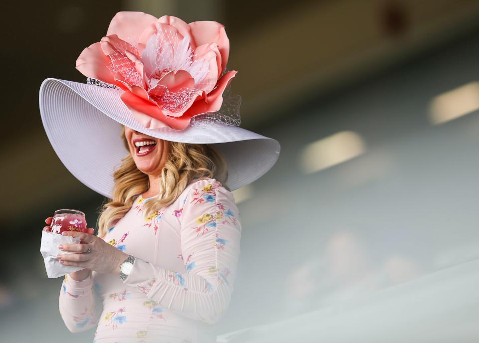 Hope Sinor wears a big hat while standing in the grandstand before the first race at Churchill Downs.  May 5, 2022