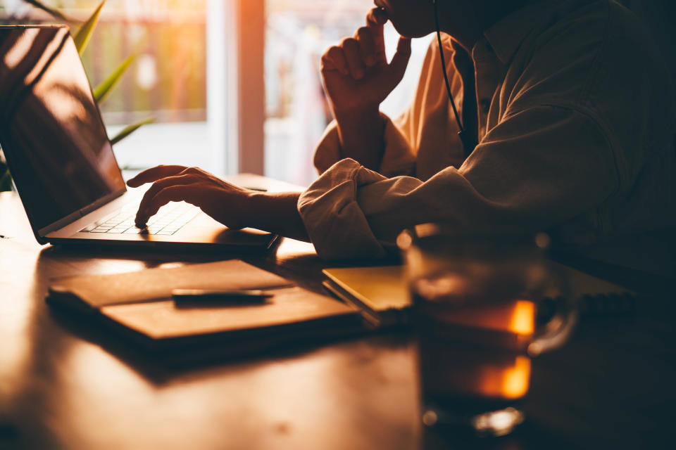 Woman writing at home at a laptop