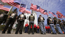 <p>Members of a veterans’ motorcycle club stand holding flags that flap in the breeze outside a memorial service for U.S. Marine Cpl. Christopher Orlando outside St. Paul’s Catholic Church in Hingham, Mass., on April 29, 2016. Orlando and 11 other Marines died on Jan. 14 in a midair collision of two helicopters during a nighttime training mission off Hawaii’s coast.<i> (Charles Krupa/AP)</i></p>