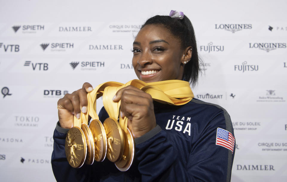 Simone Biles of the United States shows her five gold medals she won at the Gymnastics World Championships in Stuttgart, Germany, Sunday, Oct. 13, 2019. (Marijan Murat/dpa via AP)