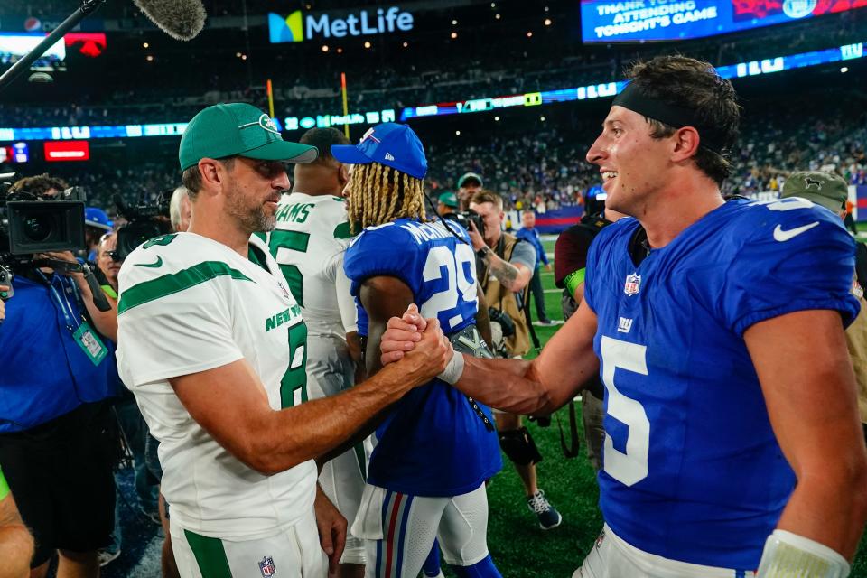 New York Jets quarterback Aaron Rodgers (8) and New York Giants quarterback Tommy DeVito (5) meet on the field during the second half of an NFL preseason football game, Saturday, Aug. 26, 2023, in East Rutherford, N.J. (AP Photo/Frank Franklin II)