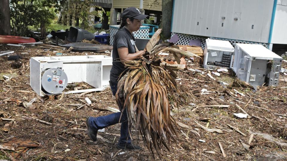 Lorena Torres cleans up debris from Hurricane Idalia at the Faraway Inn, Thursday, Aug. 31, 2023, in Cedar Key, Fla. Idalia made landfall early Wednesday morning along Florida's panhandle. (AP Photo/Chris O'Meara)