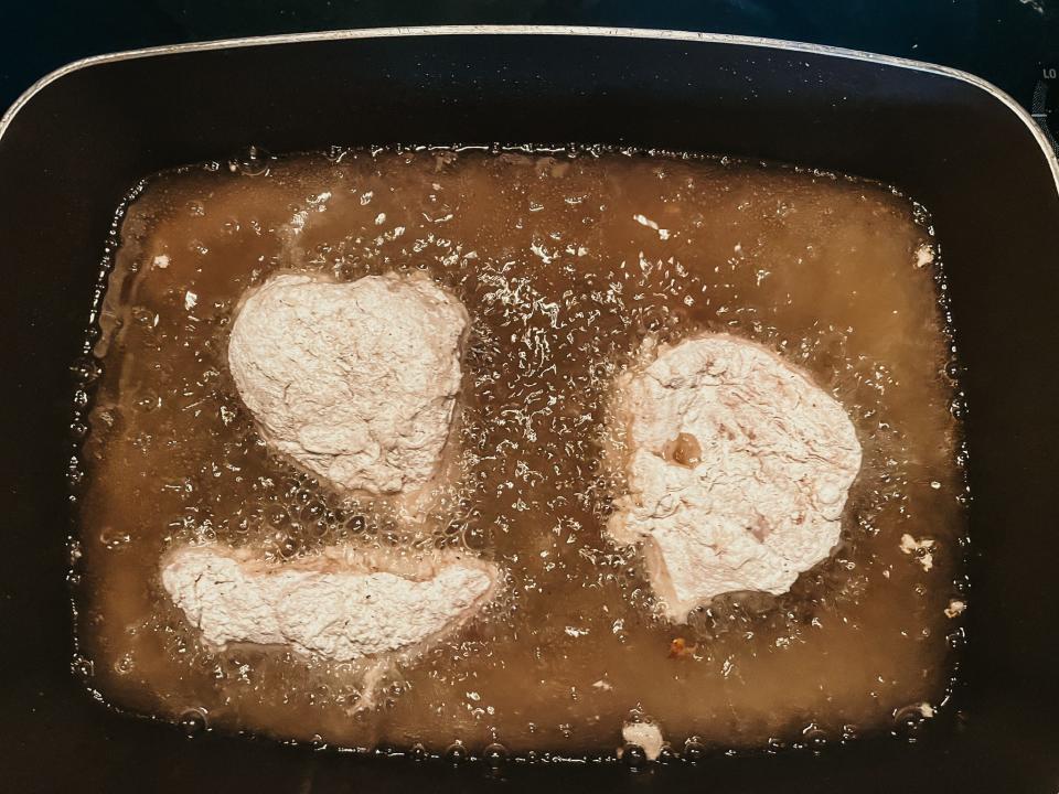 chicken frying in a pan of hot oil