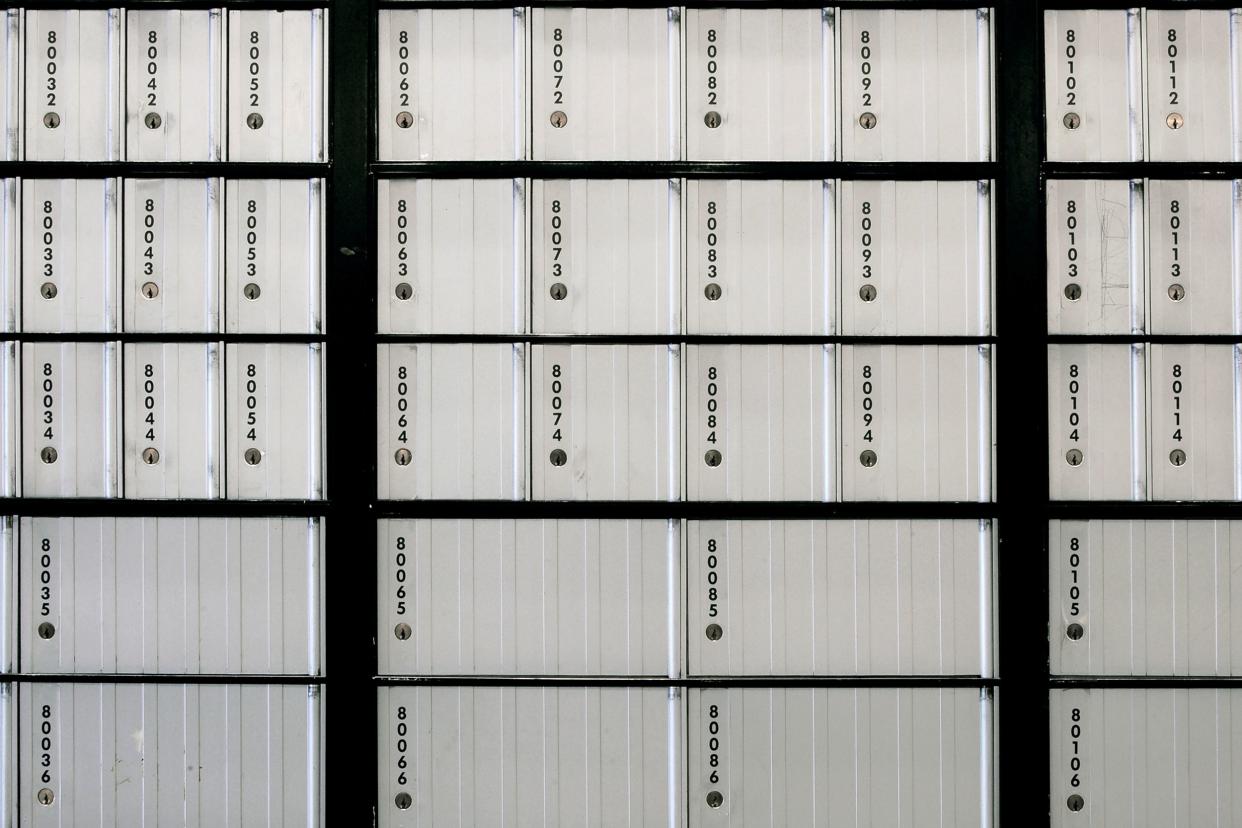 silver colored Post Office boxes both small on top three rows and large on bottom two rows