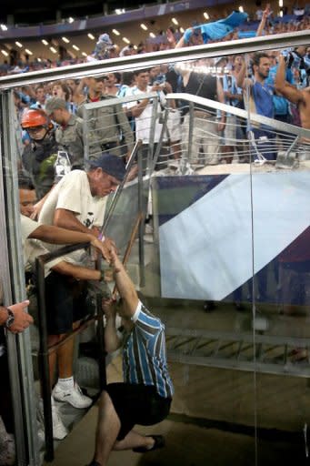 La reja de seguridad colocada al final de una de las tribunas cedió cuando la hinchada se lanzó en una avalancha para celebrar un gol de Elano (61). (AFP | Jefferson Bernardes)