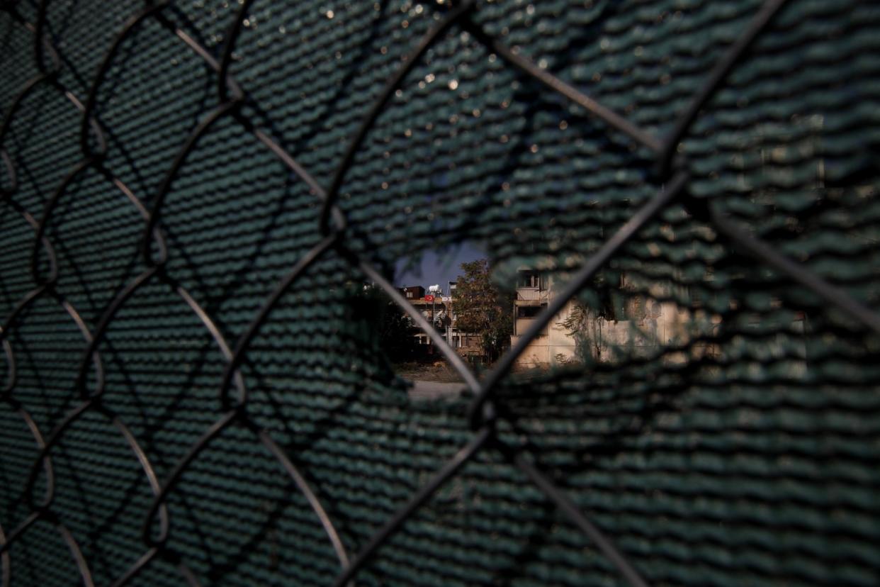 A Turkish flag can be seen through a hole in the fence which divides the capital of Cyprus in two: AP