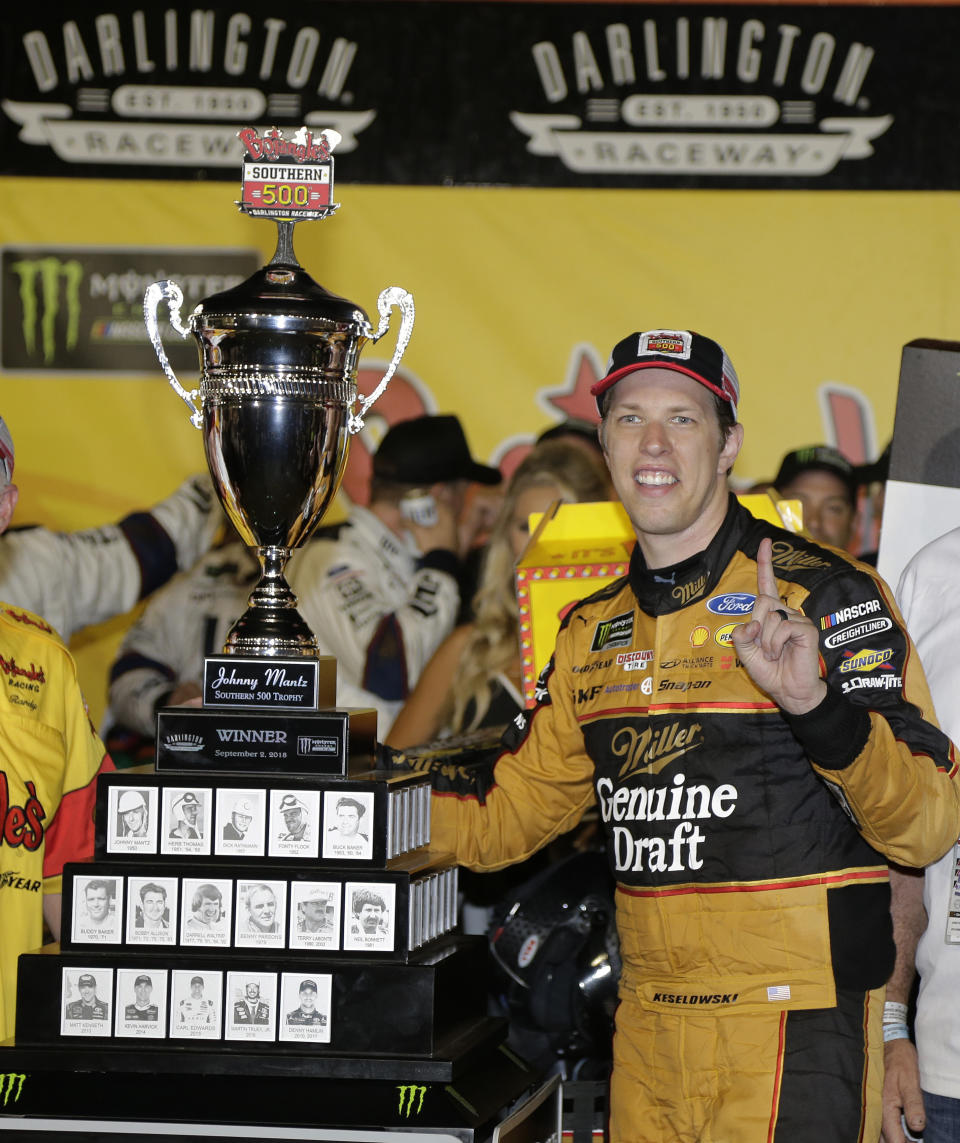 Brad Keselowski stands by his trophy after winning the NASCAR Cup Series auto race at Darlington Raceway, Sunday, Sept. 2, 2018, in Darlington, S.C. (AP Photo/Terry Renna)