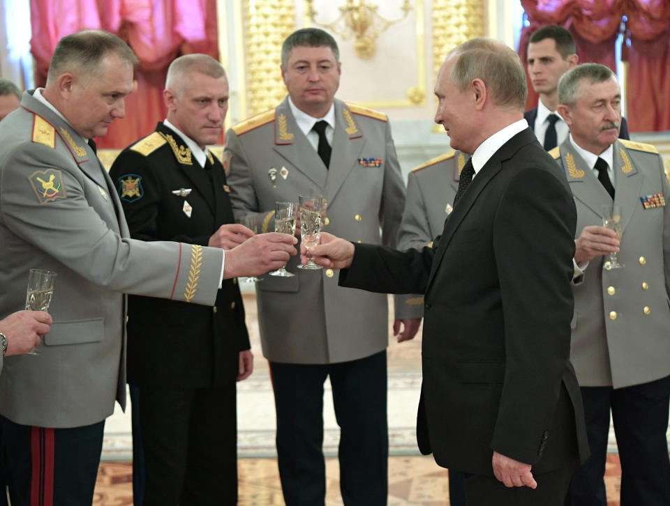 Russian President Vladimir Putin, foreground right, toasts with top military officers and law enforcement officials in the Kremlin in Moscow, Russia, Thursday, Oct. 25, 2018. Putin said that Russia has adhered to its obligations in the arms control sphere, but noted that Russian arsenals will be modernized to ensure protection from any potential threats. (Alexei Nikolsky, Sputnik, Kremlin Pool Photo via AP)