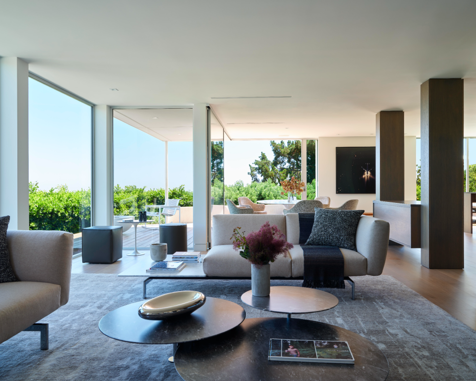 Minimal living room with trio of coffee tables, gray large area rug and minimal table decor