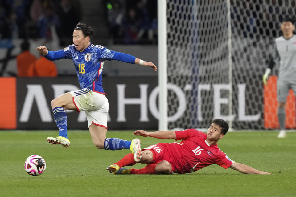 Japan's Takuma Asano, left, and North Korea's Kim Yu Song competes for the ball during the FIFA World Cup 2026 and AFC Asian Cup 2027 preliminary joint qualification round 2 match between Japan and North Korea at the National Stadium Thursday, March 21, 2024, in Tokyo. (AP Photo/Eugene Hoshiko)