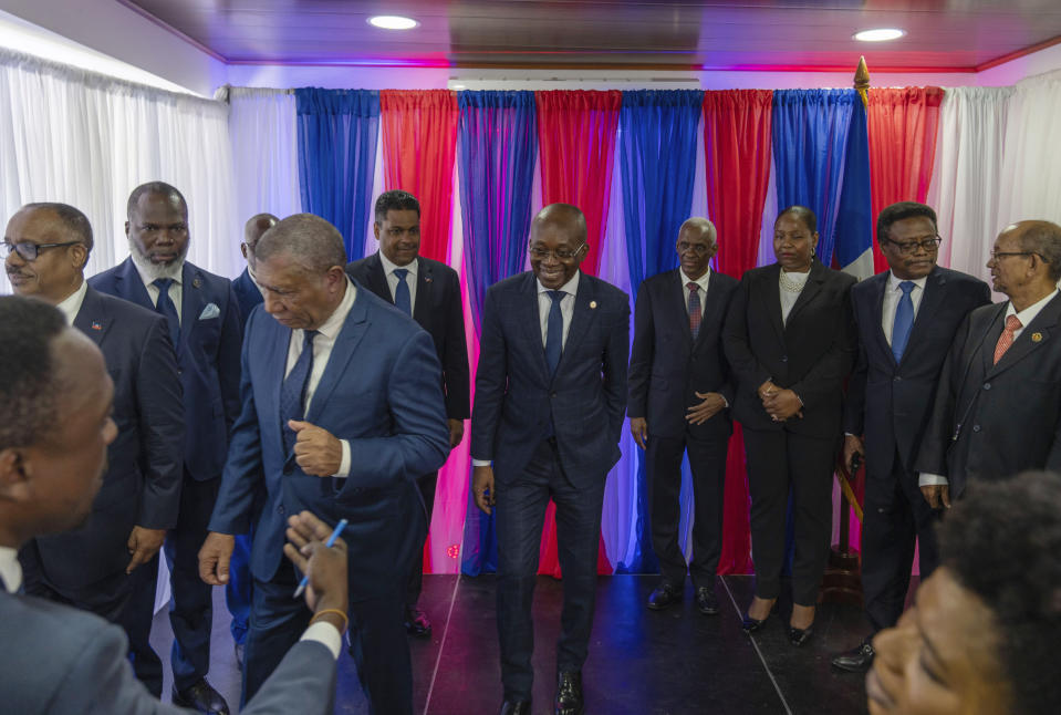 Michel Patrick Boisvert, center, who was named interim prime minister by the cabinet of outgoing Prime Minister Ariel Henry, smiles after posing with members of a transitional council tasked with selecting Haiti's new prime minister and cabinet, in Port-au-Prince, Haiti, Thursday, April 25, 2024. Boisvert was previously the economy and finance minister. (AP Photo/Ramon Espinosa)