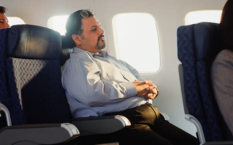 An overweight passenger on a plane - Credit: Getty