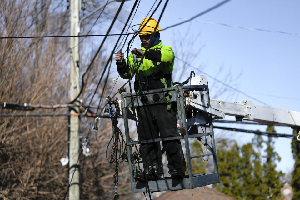 A utility worker works on lines in Detroit, Tuesday, Feb. 28, 2023. A new storm teeming with freezing rain and strong winds socked Michigan on Monday, presenting a fresh challenge for crews that have been trying to restore electricity to thousands of customers who have been in the dark since ice snapped lines days ago. (AP Photo/Paul Sancya)