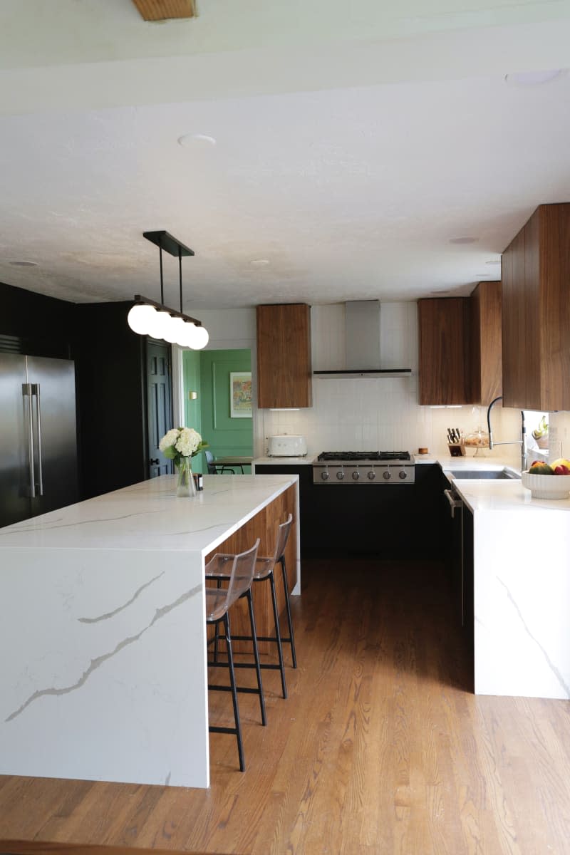 A linear pendant above the white waterfall kitchen island.