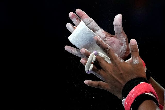 The hands of an athlete as she prepares to use the uneven bars in a gymnastics training session ahead of the Birmingham 2022 Commonwealth Games in Birmingham, England