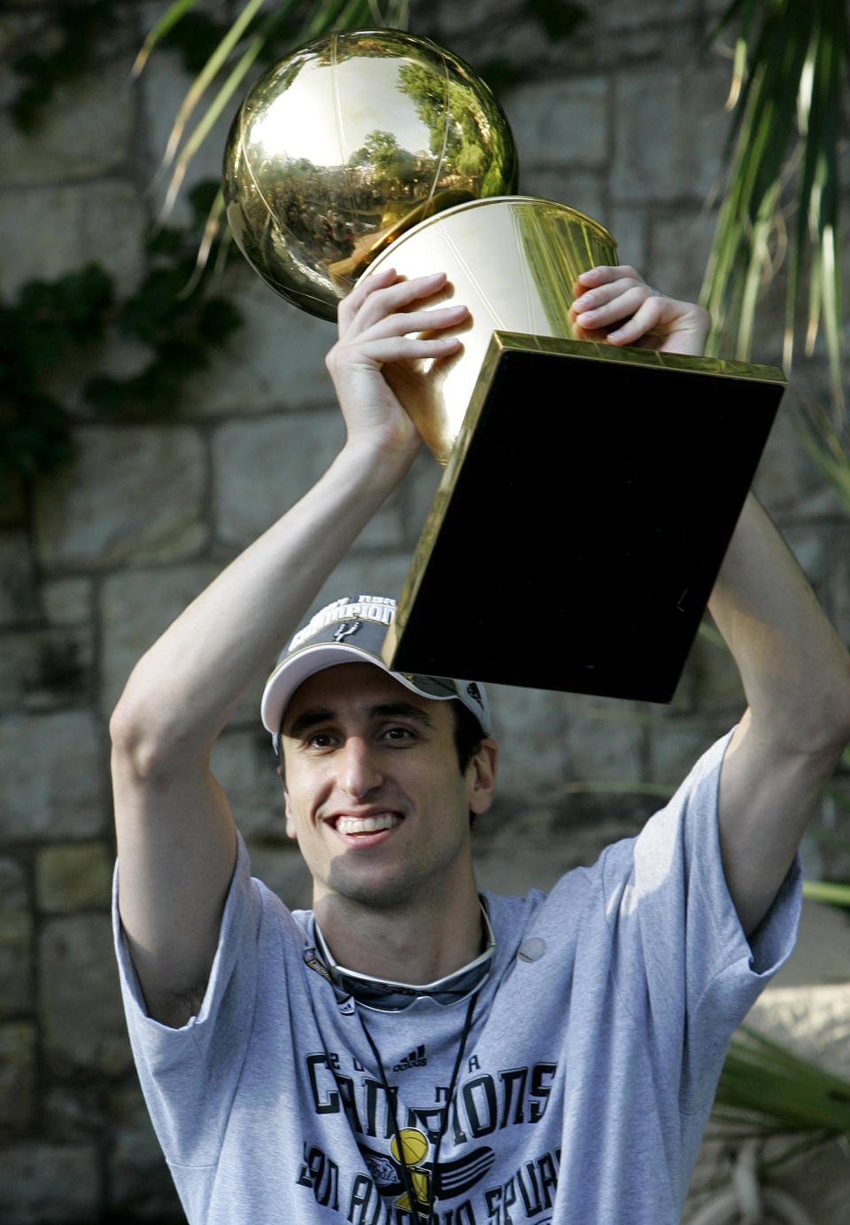 FILE - In this June 17, 2007, file photo, San Antonio Spurs guard Manu Ginobili, of Argentina, holds the Larry O'Brien Championship Trophy as he and teammates take part in a river parade to celebrate winning the NBA Basketball Championship, in San Antonio. Ginobili retired at age 41 Monday, Aug. 27, 2018, after a "fabulous journey" in which he helped the Spurs win four NBA championships in 16 seasons with the club. (AP Photo/Eric Gay, File)