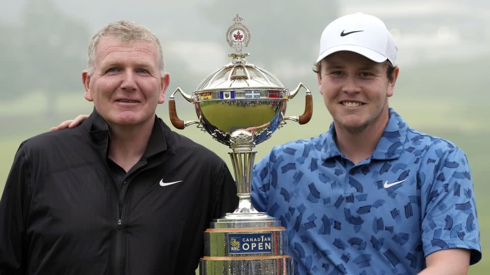 Father and son pose with the trophy. - Frank Gunn/The Canadian Press/AP