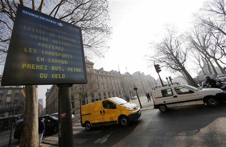 A Paris city information board which reads, "Pollution - Avoid taking your cars; prefer public transportations, take the bus or your bicycle", is seen along a street in Paris March 14, 2014, as warm and sunny weather continues in France. REUTERS/Jacky Naegelen