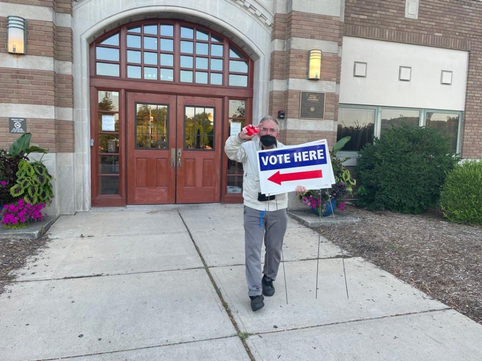 William Rittenberg takes down signs at 8:03 p.m. in front of the Hannah Community Center in East Lansing, letting voters know the polls have closed.