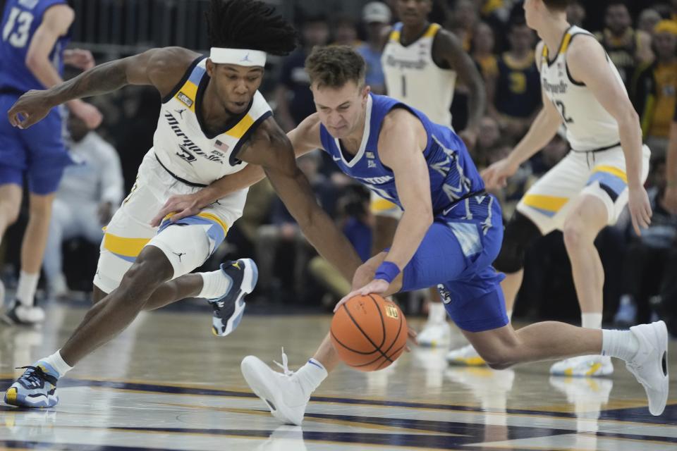 Marquette's Chase Ross and Creighton's Steven Ashworth go after a loose ball during the first half of an NCAA college basketball game Saturday, Dec. 30, 2023, in Milwaukee. (AP Photo/Morry Gash)