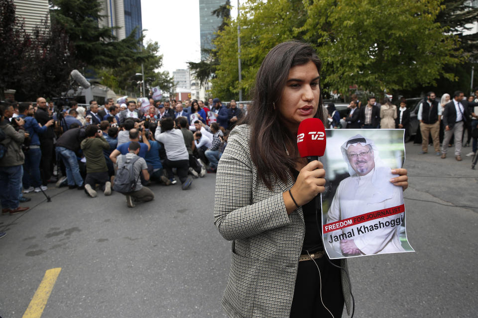 A journalist holding a poster of missing Saudi writer Jamal Khashoggi, speaks to camera near the Saudi Arabia consulate in Istanbul, Monday, Oct. 8, 2018. Khashoggi, 59, went missing on Oct 2 while on a visit to the consulate in Istanbul for paperwork to marry his Turkish fiancée. The consulate insists the writer left its premises, contradicting Turkish officials. He had been living since last year in the U.S. in a self-imposed exile, in part due to the rise of Prince Mohammed, the son of King Salman. (AP Photo/Lefteris Pitarakis)