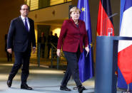 German Chancellor Angela Merkel and French President Francois Hollande arrive for a news conference after talks on a stalled peace plan for eastern Ukraine at the chancellery in Berlin, Germany, October 20, 2016. REUTERS/Hannibal Hanschke