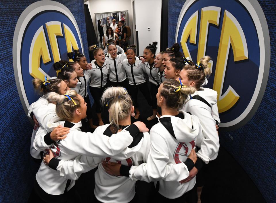 Alabama gymnasts gather in a hallway and chant together as they get ready to compete in the the SEC Gymnastics Championship at Legacy Arena in Birmingham Saturday, March 19, 2022.