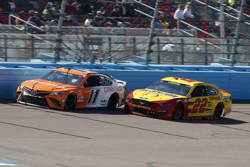 Denny Hamlin (11) and Joey Logano (22) race through Turn 4 during a NASCAR Cup Series auto race at Phoenix Raceway, Sunday, March 14, 2021, in Avondale, Ariz. (AP Photo/Ralph Freso)