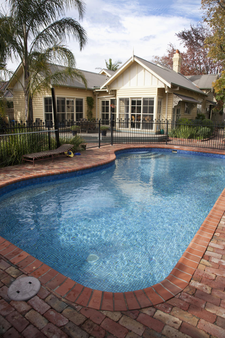 Weatherboard circa 1920 house in Australia with swimming pool in rear yard behind house.