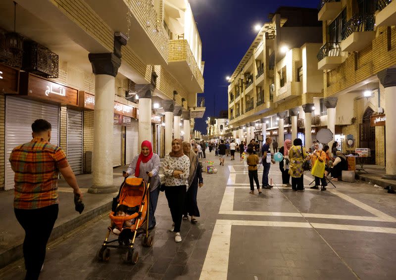 Iraqi residents walk along Mutanabbi Street in Baghdad