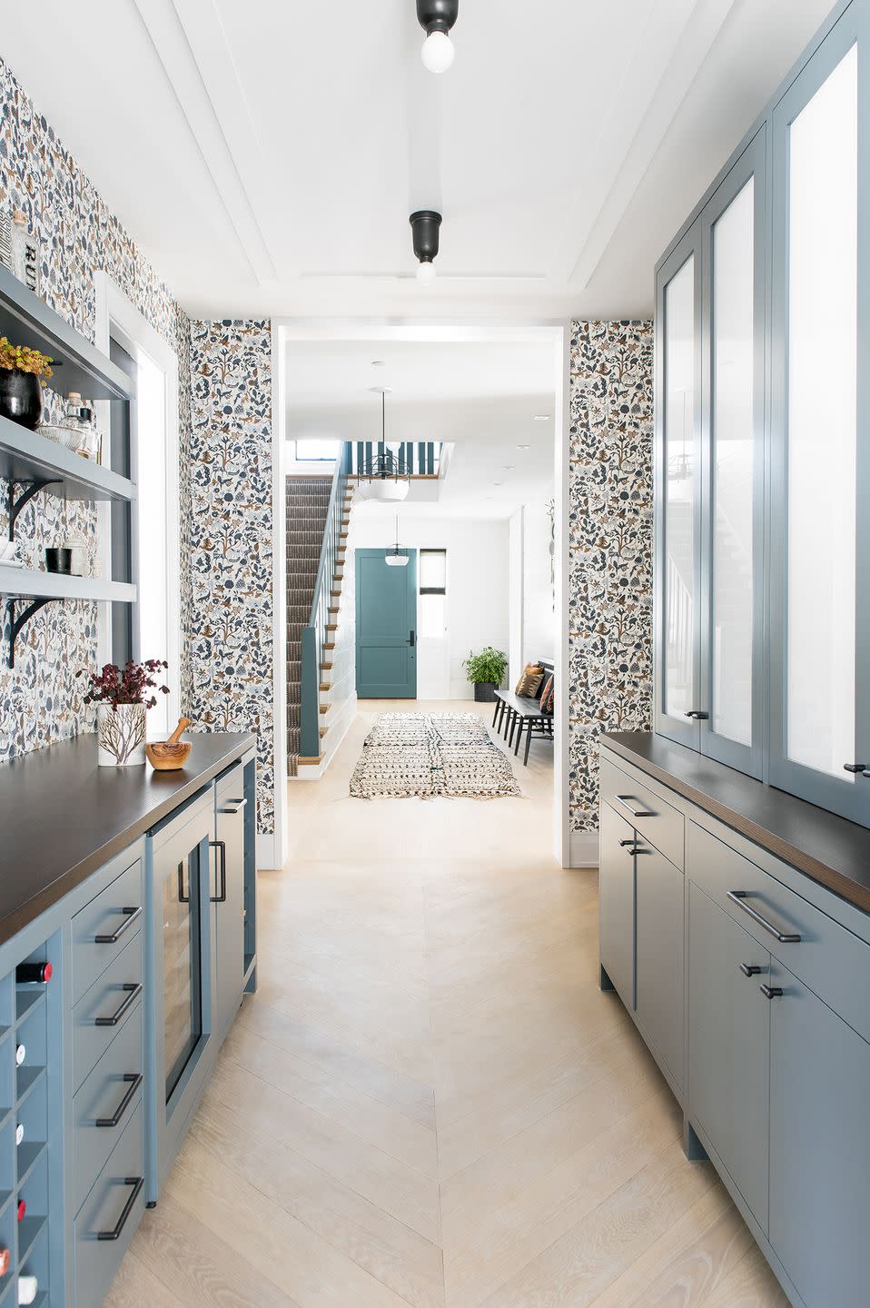 butler pantry galley kitchen with floral wallpaper and blue cabinets