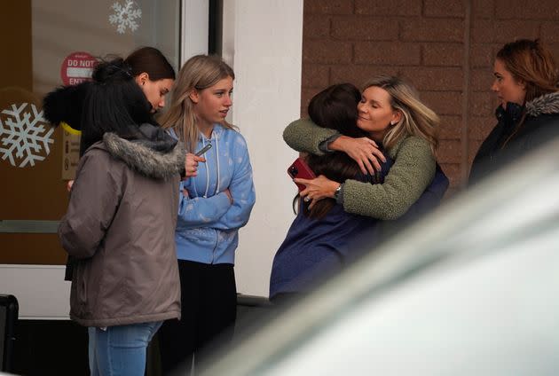 A parent hugs a child as others come to pick up students from the Meijer store in Oxford, Michigan, following a shooting at Oxford High School on Tuesday. (Photo: via Associated Press)
