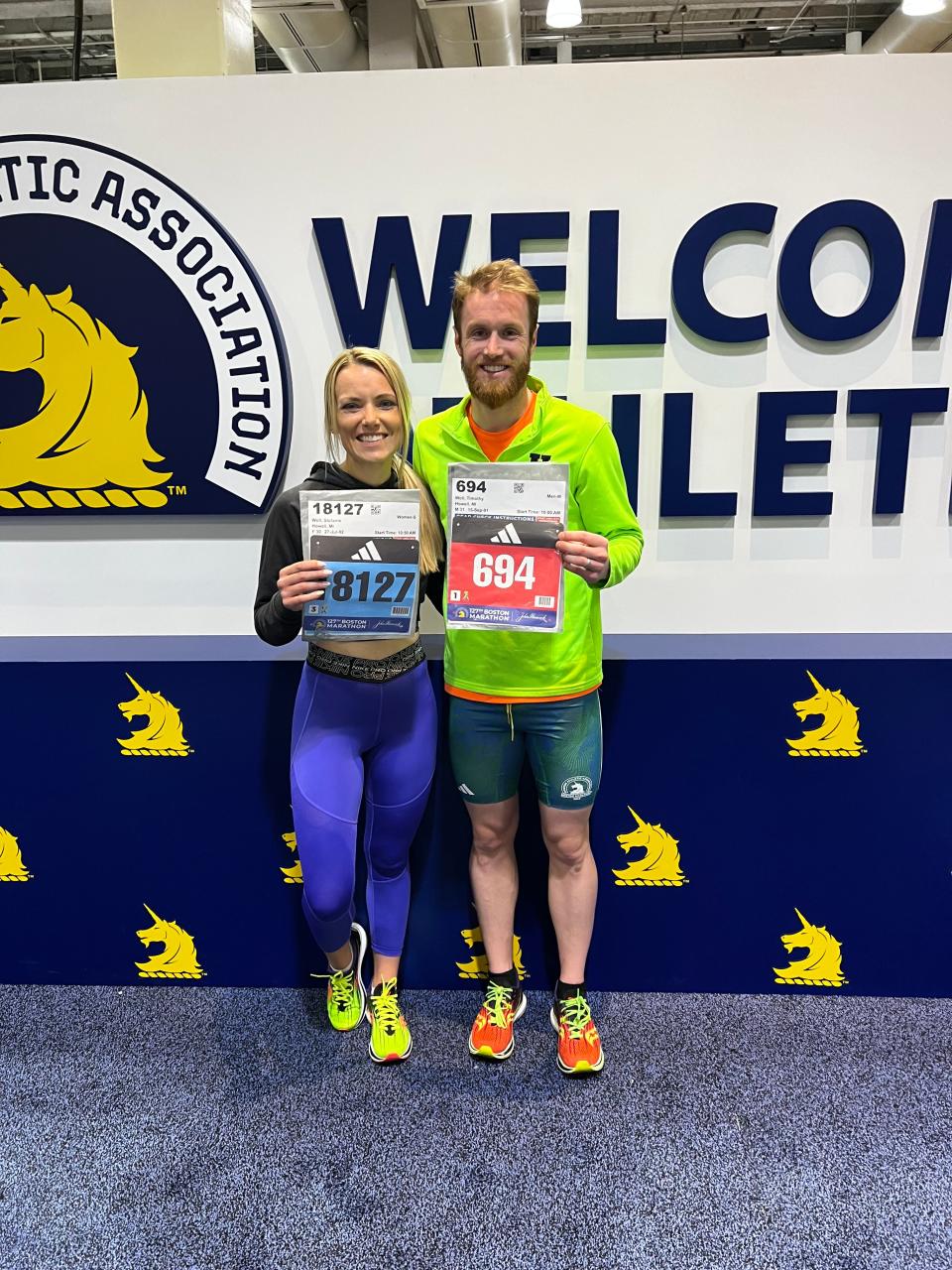 Stefanie (left) and Clay Woll of Howell show their bib numbers prior to the 2023 Boston Marathon.