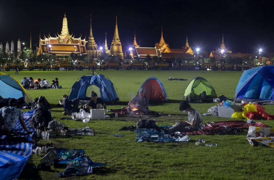 Pro-democracy protesters who occupied Sanam Luang, a historic field for an over-night protest rally, cook a meal in Bangkok, Thailand, early Sunday, Sept. 20, 2020. Thousands of demonstrators turned out Saturday for a rally to support the student-led protest movement's demands for new elections and reform of the monarchy. (AP Photo/Gemunu Amarasinghe)