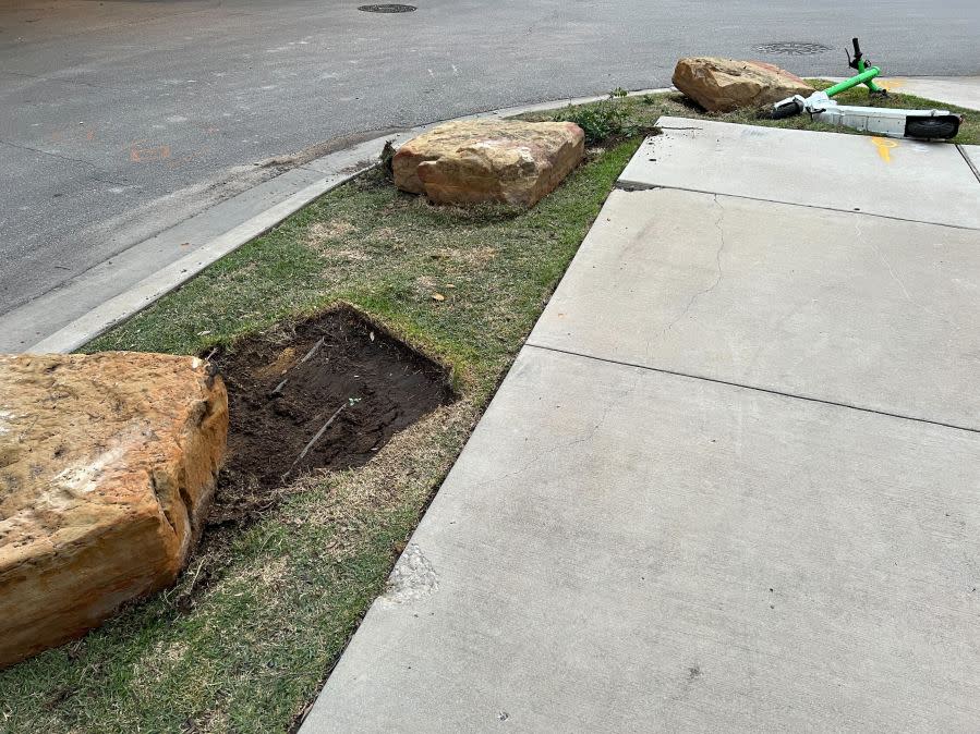 Damage to cars, street signs, etc. along East 9th Street near Embassy Drive after an 18-wheeler crashed into 10 parked vehicles overnight April 22, 2024 (KXAN Photo/Todd Bailey)