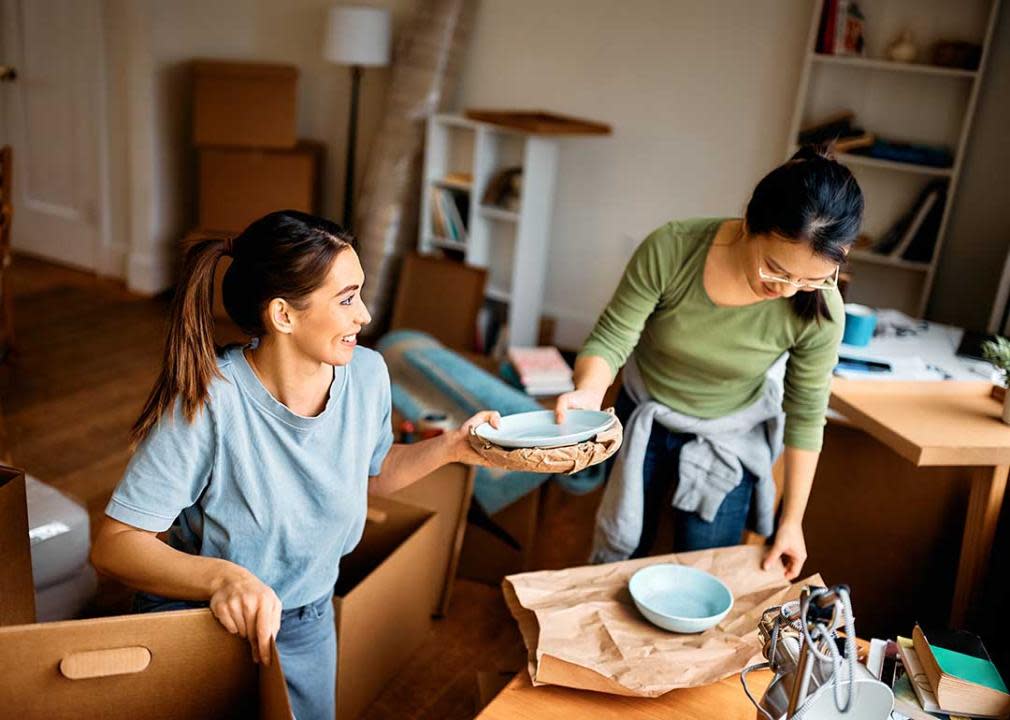 Two women unpacking boxes.