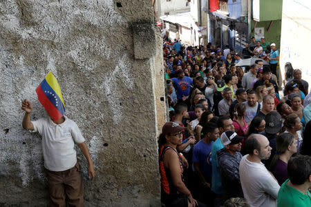 Venezuelan citizens wait in line at a polling station during a nationwide election for new governors in Caracas, Venezuela. REUTERS/Ricardo Moraes