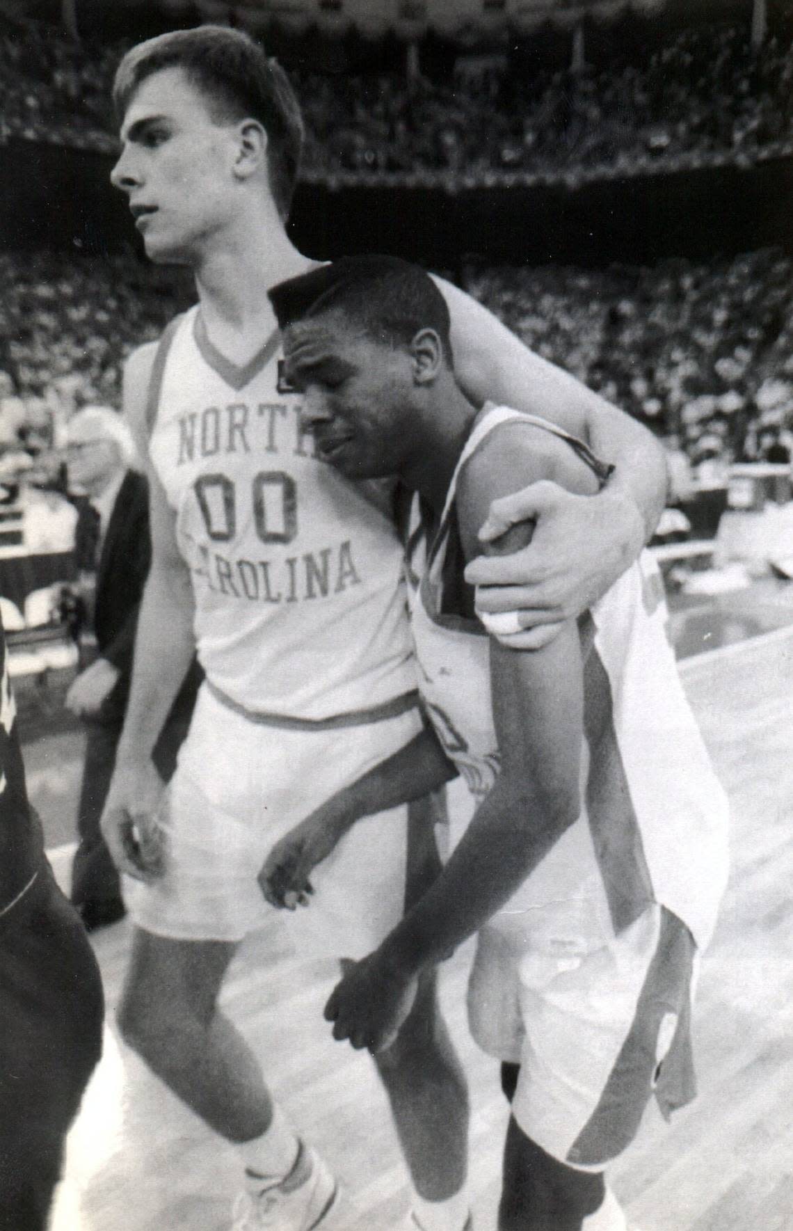 UNC’s Hubert Davis, right, is consoled by teammate Eric Montross after the Tarheels were defeated by the Kansas Jayhawks in the semifinals of the NCAA tournament at the Hoosier Dome March 30, 1991.