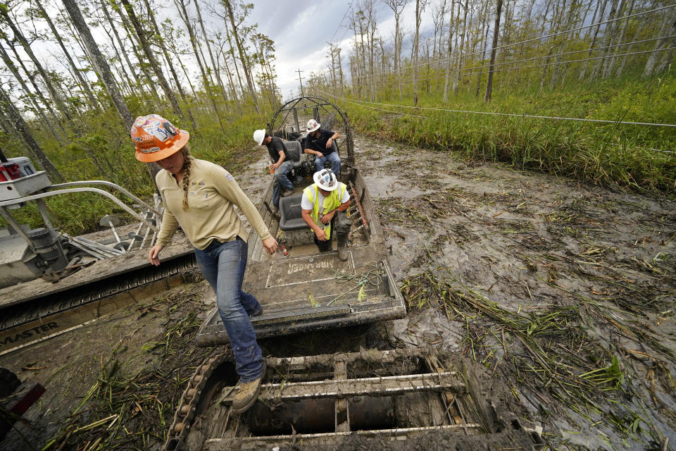 Shannon Beebe, an electrical worker for Sparks Energy, arrives in a marsh buggy to restore power lines running through a marsh in the aftermath of Hurricane Ida in Houma, La., Friday, Sept. 17, 2021. The Louisiana terrain presents special challenges. In some areas, lines thread through thick swamps that can be accessed only by air boat or marsh buggy, which looks like a cross between a tank and a pontoon boat. Workers don waders to climb into muddy, chest-high waters home to alligators and water moccasins. (AP Photo/Gerald Herbert)