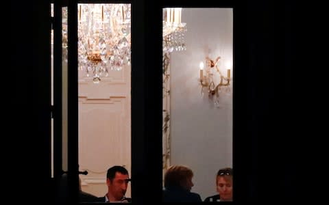 Leaders of the German Green Party Cem Ozdemir and Simone Peter and Mrs Merkel are seen through the window of German Parliamentary Society offices during the exploratory talks - Credit: Reuters