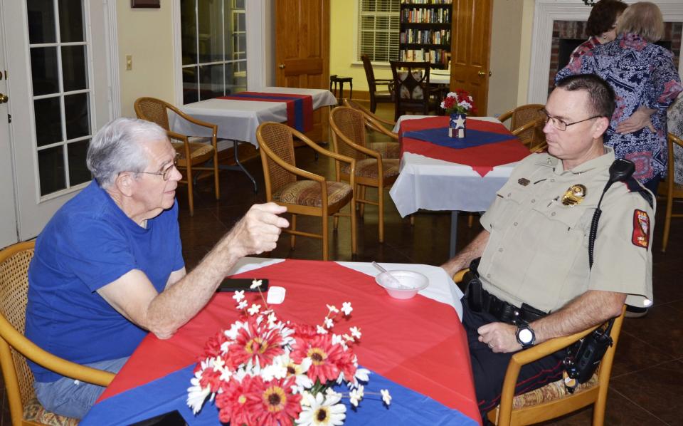 Gary Peitz, left, talks with Madison Police Officer Chris Wallace during Night Out festivities held at Geneva Gardens Clubhouse in Madison on Tuesday, Oct. 3.