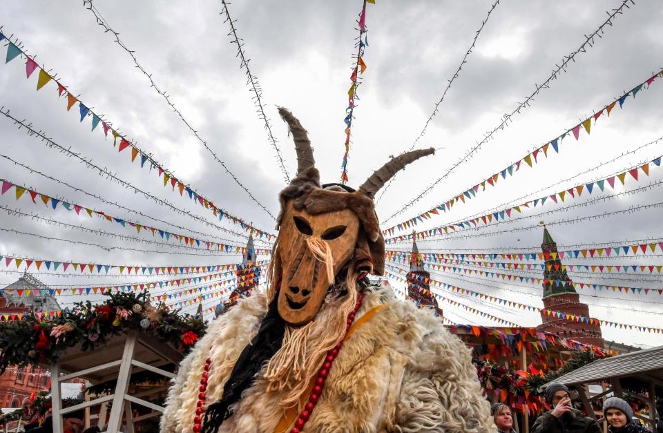 A performer wearing a scary mask entertains the public during the Shrovetide Spring festival near the Kremlin in Moscow on Feb. 24, 2020.  Shrovetide or Maslenitsa is an ancient farewell ceremony to winter, traditionally celebrated in Belarus, Russia and Ukraine and involves the burning of a large effigy. 