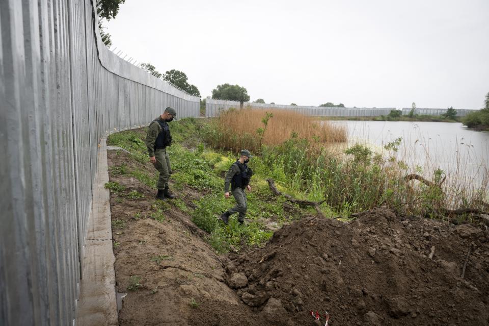 FILE - In this Friday, May 21, 2021, policemen patrol alongside a steel wall at Evros river, near the village of Poros, at the Greek -Turkish border, Greece. Greece's prime minister and Turkey's president are to speak Friday evening, Aug. 20, to discuss "the latest developments in Afghanistan." Both countries are raising concerns about facing a potential major influx of people fleeing Afghanistan after the Taliban's takeover. (AP Photo/Giannis Papanikos, File)