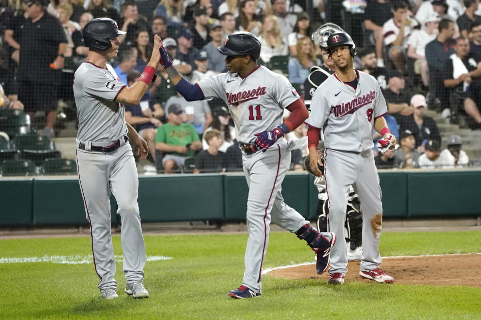 Minnesota Twins' Jorge Polanco (11) celebrates his three-run home run off Chicago White Sox relief pitcher Codi Heuer, with Max Kepler, left, and Andrelton Simmons, during the sixth inning of a baseball game Wednesday, July 21, 2021, in Chicago. (AP Photo/Charles Rex Arbogast)