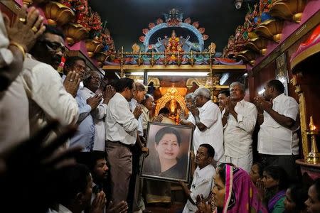 Well wishers of Tamil Nadu Chief Minister Jayalalithaa Jayaraman hold her portrait as they pray at a temple in Mumbai, India, December 5, 2016. REUTERS/Danish Siddiqui